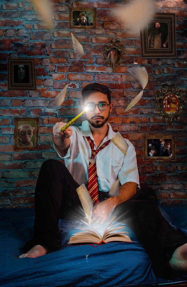 A man dressed in wizard-like attire performs magic with a wand in a mystical setting.