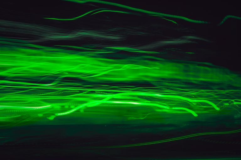 Dynamic abstract image of vibrant green light trails in motion, creating a futuristic feel.