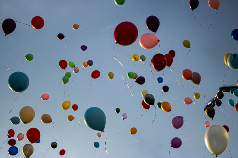Vibrant and cheerful balloons ascending into a clear blue sky.