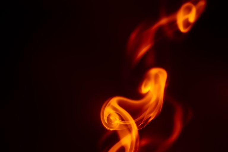Vibrant orange flames create a mesmerizing abstract pattern on a dark background.
