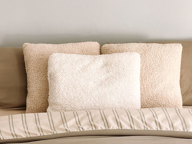 Warm and inviting bedroom with soft, fluffy pillows and neutral bedding for a cozy ambiance.
